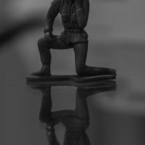 A black and white photo of a toy solider on a table